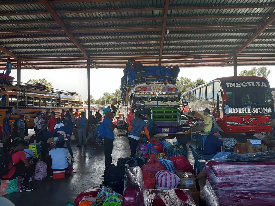 Buses and market stalls under the roof of a bus terminal in Managua
