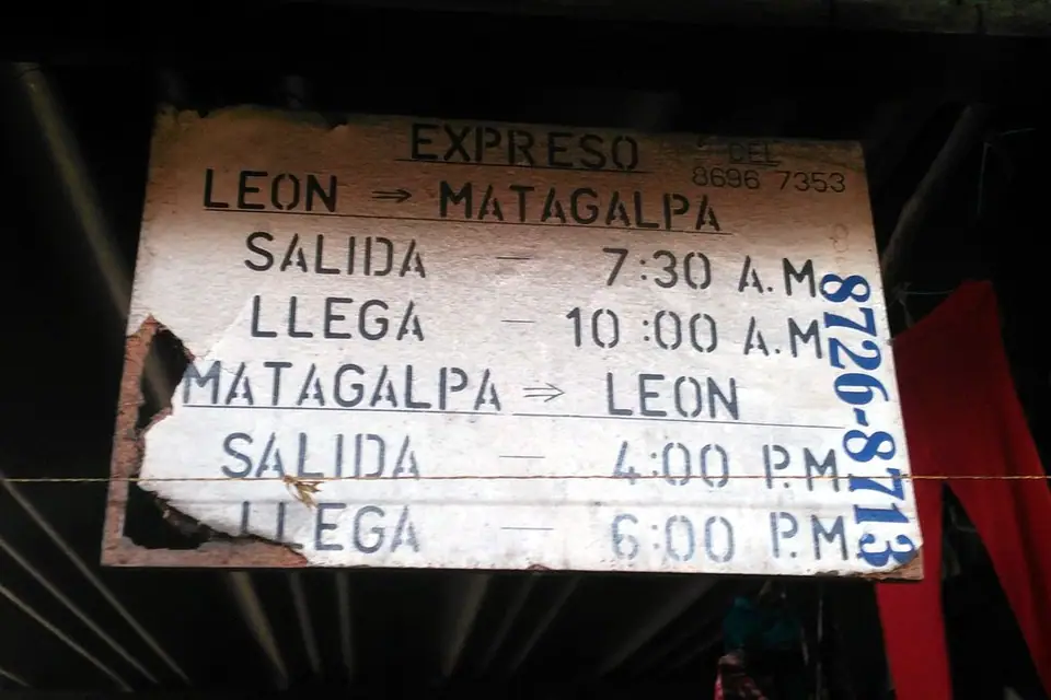 Rótulo pintado a mano en la terminal de León: expreso León–Matagalpa, sale 7:30 a. m. y llega 10:00 a. m.
